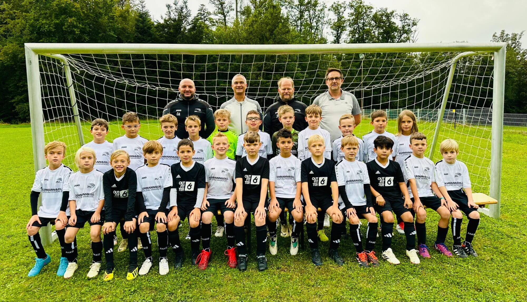 Fußballteam mit Jungen, die in einheitlichen Trikots für ein Gruppenfoto posieren.